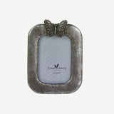 Small photo frame with a butterfly decoration on top in antique silver colour`