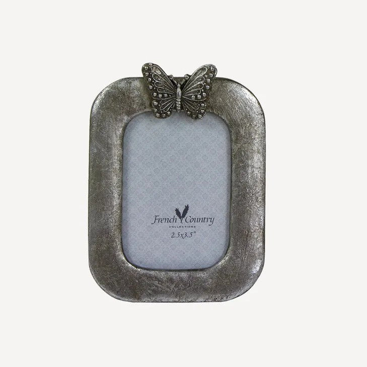Small photo frame with a butterfly decoration on top in antique silver colour`
