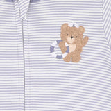 Close-up of a baby outfit with a teddy bear design on a striped background