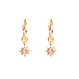 Gold star-shaped earrings with a central gemstone on a white background