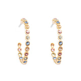 Gold hoop earrings with multicolored gemstones on a white background