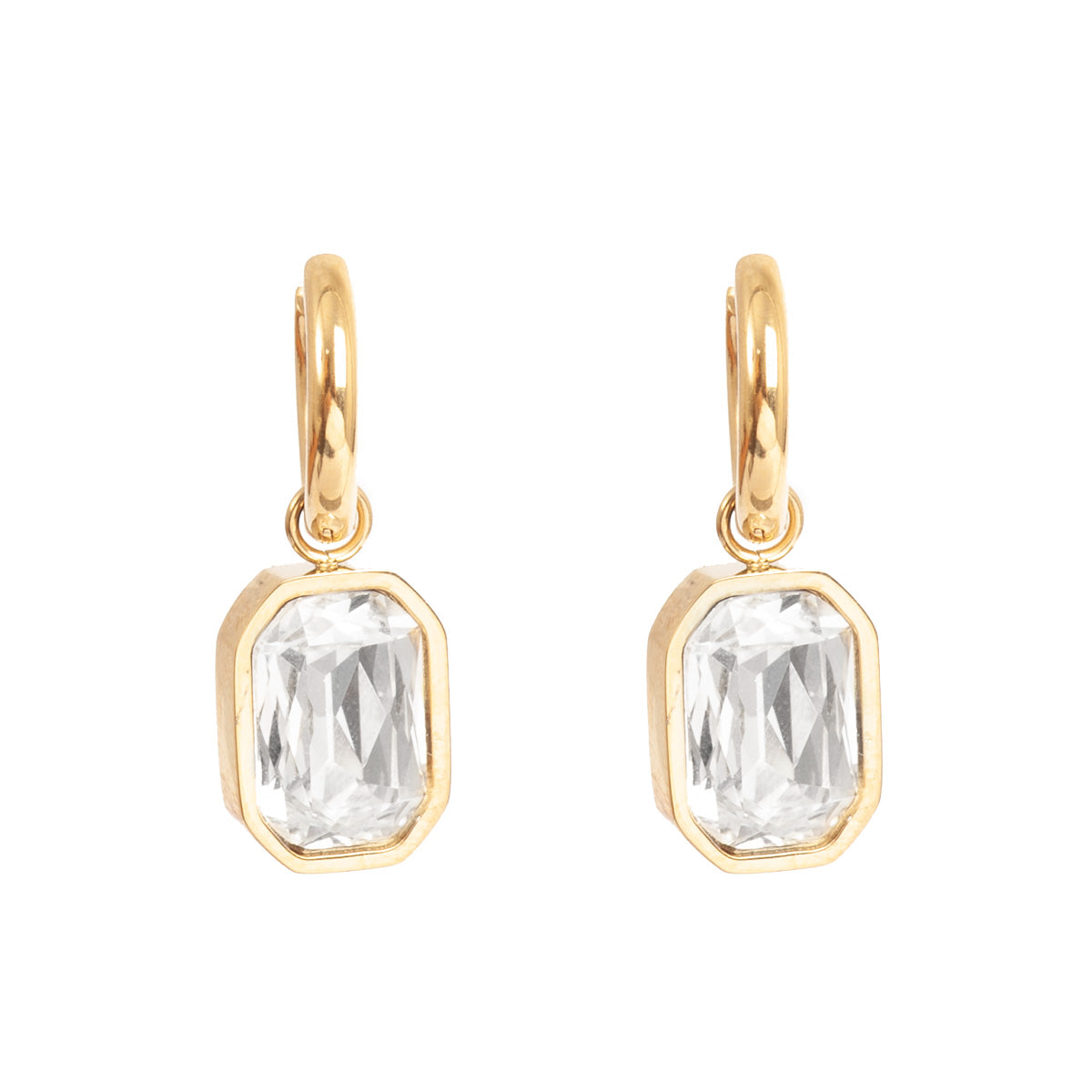 Gold earrings with clear crystals on a white background