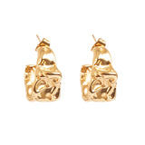 Gold chunky crinkle look hoop earrings on a white background