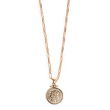 Gold necklace with a round pendant on a white background