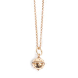 Gold necklace with a spherical pendant on a white background