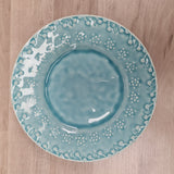 Blue ceramic plate with white floral patterns on a wooden surface