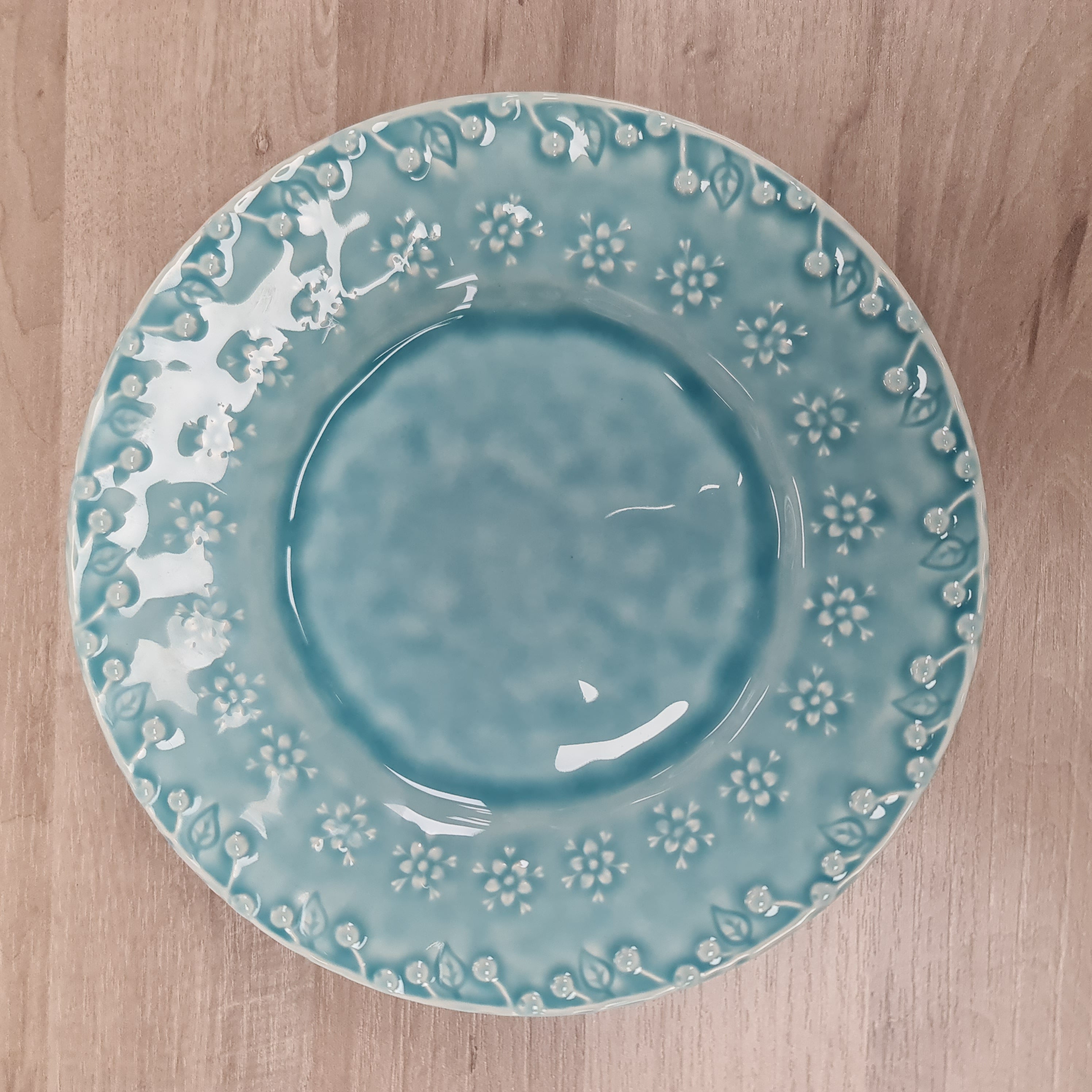 Blue ceramic plate with white floral patterns on a wooden surface