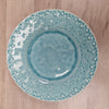 Blue ceramic plate with white floral patterns on a wooden surface