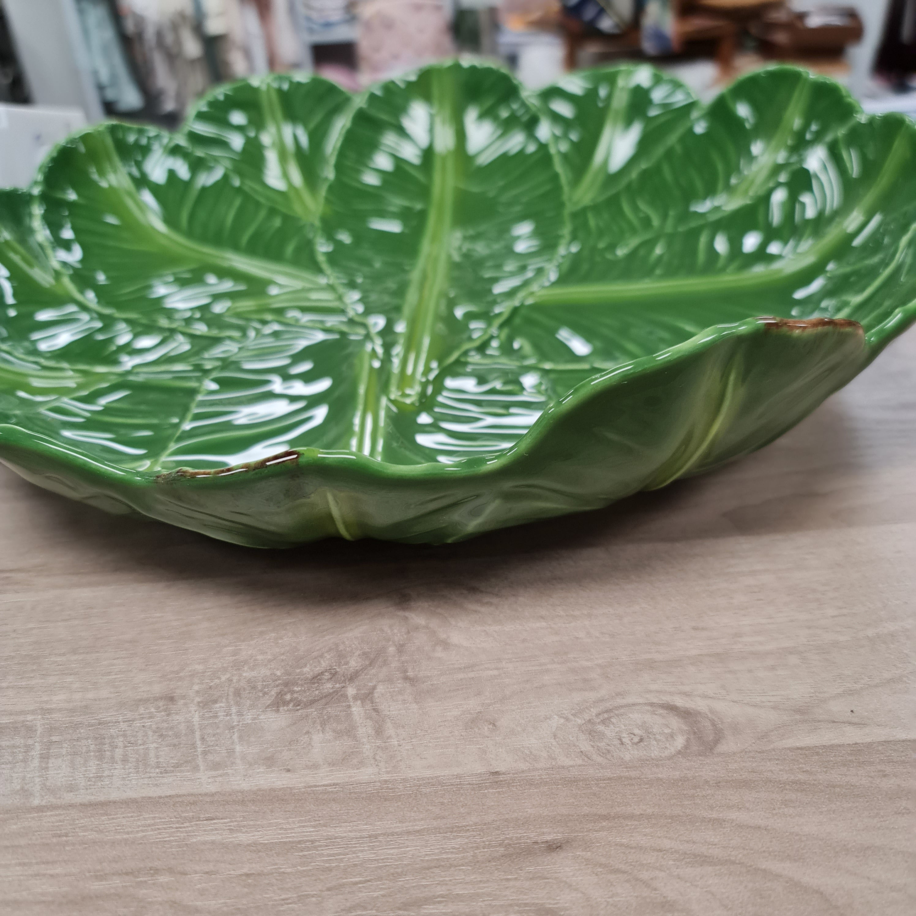 Green leaf-shaped object on a wooden surface