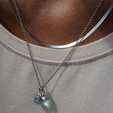 Silver necklace with blue glass and crystal pendants on model