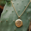 Gold engraved round locket pendant on long chain