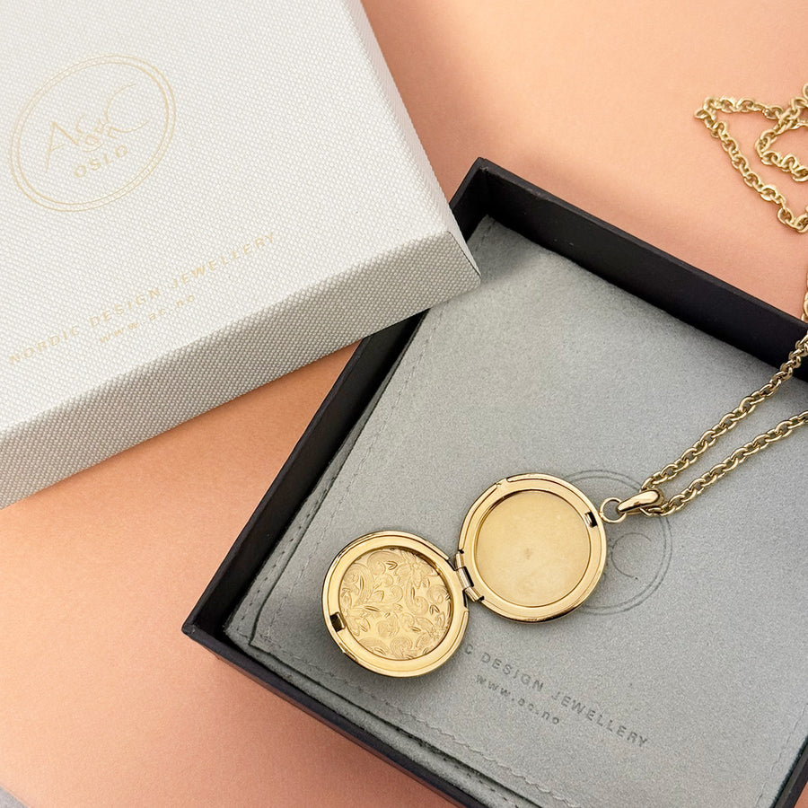 Gold engraved round locket pendant on long chain in box with A & C logo