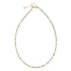 Necklace with small gold and green beads on a white background