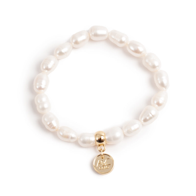 Pearl bracelet with a gold charm on a white background
