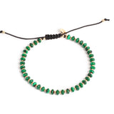Green beaded necklace with black cord on a white background