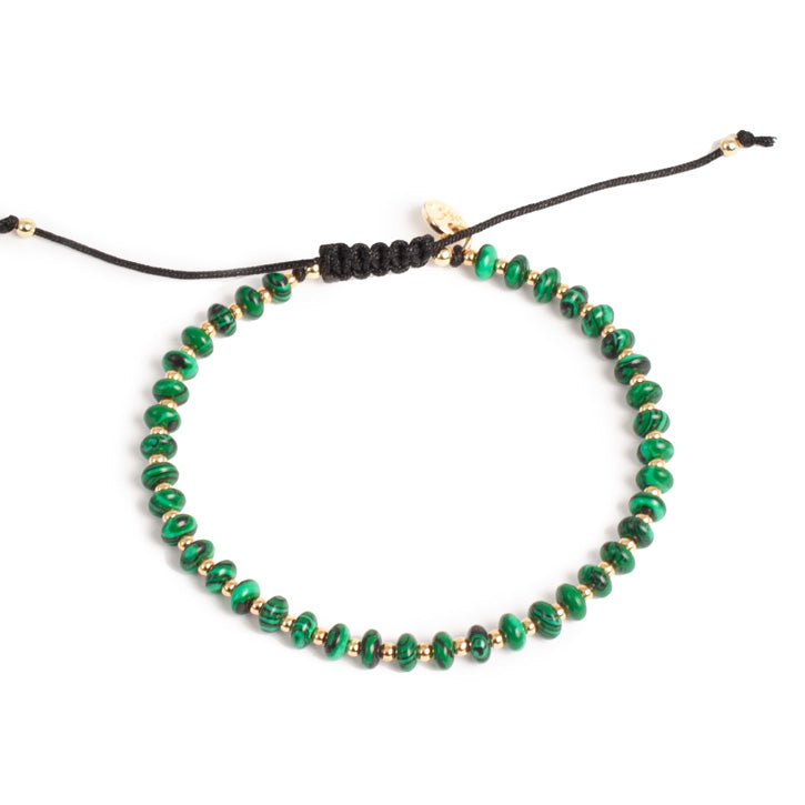 Green beaded necklace with black cord on a white background
