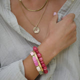 Colour ful bracelet in pink, green and natural enamel disks with gold bars.