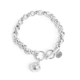 Silver chain bracelet with a toggle clasp and round charm on a white background