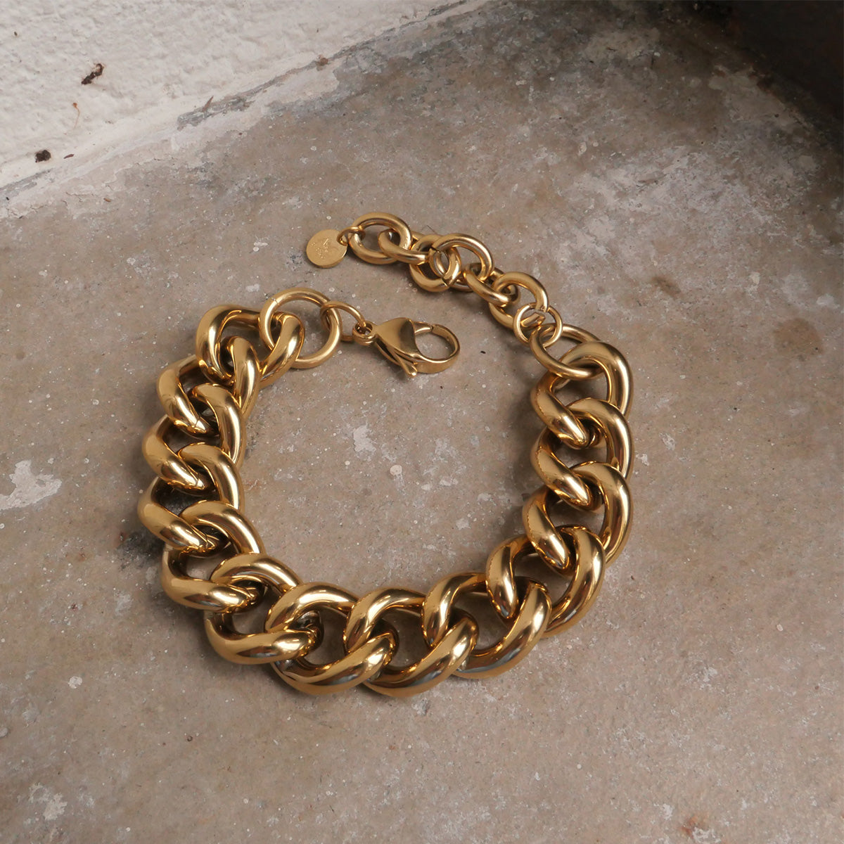 Gold chain bracelet on a textured surface