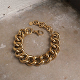 Gold chain bracelet on a textured surface