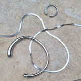 Silver necklaces, bracelet and earrings on a textured surface