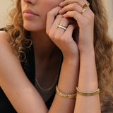 Person wearing gold and crystal bracelets on her arm