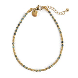 Bracelet with gold and green beads on a white background