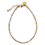 Gold and blue beaded bracelet on a white background