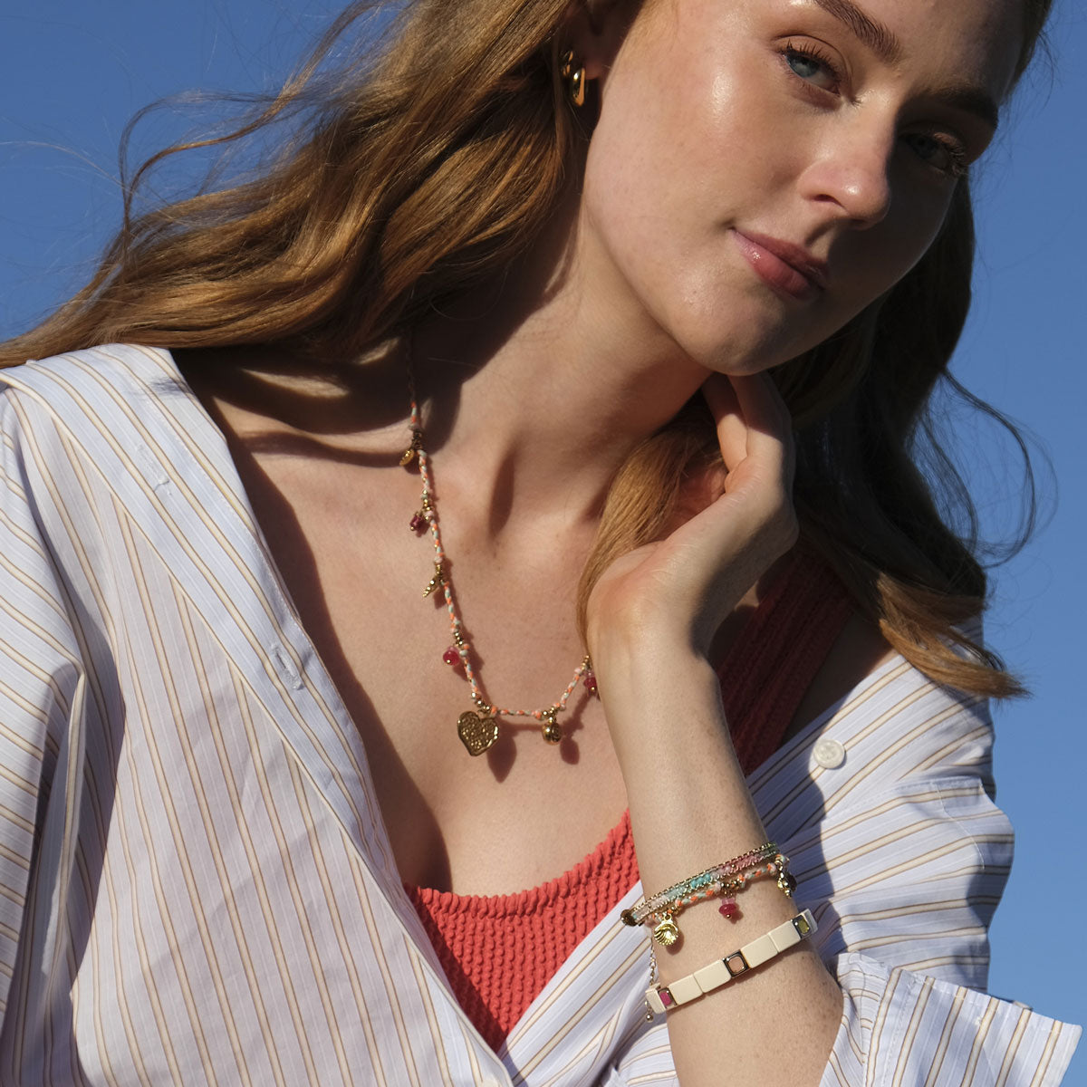 Model wearing a collection of A&C Oslo Jewellery including the colourful semi precious stone bracelet, corded necklace and matching bracelet with charms.  Also teamed up with the cream and gold enamel bracelet at Cerise NZ.