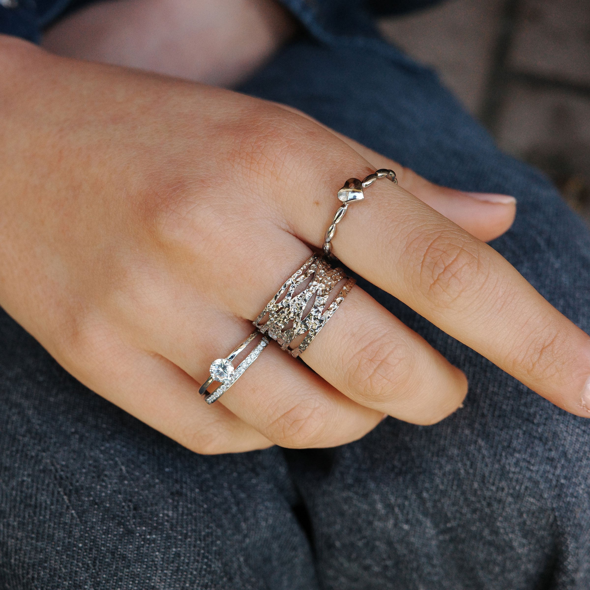 The silver heart buuble ring from A&C Oslo, made from 316 polished steel this goregous wittle ring features rice shaped bubbles on the band with a dainty silver heart in the centre. Shown here  with other silver rings for a layered look. Available in sizes small, medium and large at Cerise.