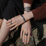 A&C Oslo Steel Big Waves Ring in Silver. A chunky silver ring shown here on a model with the silver bubble heart ring for a layered look. Avaialbe  in sizes small, medium and large at Cerise.