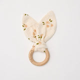 Over the Dandelions soft organic cotton muslin baby teether with beechwood teething ring. In a daisy print pattern at Cerise