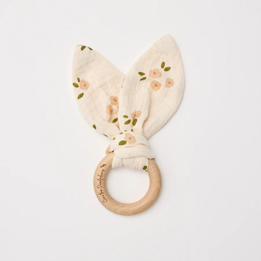 Over the Dandelions soft organic cotton muslin baby teether with beechwood teething ring. In a daisy print pattern at Cerise