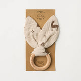 Over the Dandelions soft organic cotton muslin baby teether with beechwood teething ring. In a Woodlands print pattern at Cerise