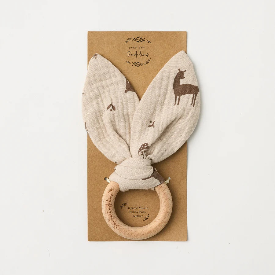 Over the Dandelions soft organic cotton muslin baby teether with beechwood teething ring. In a Woodlands print pattern at Cerise
