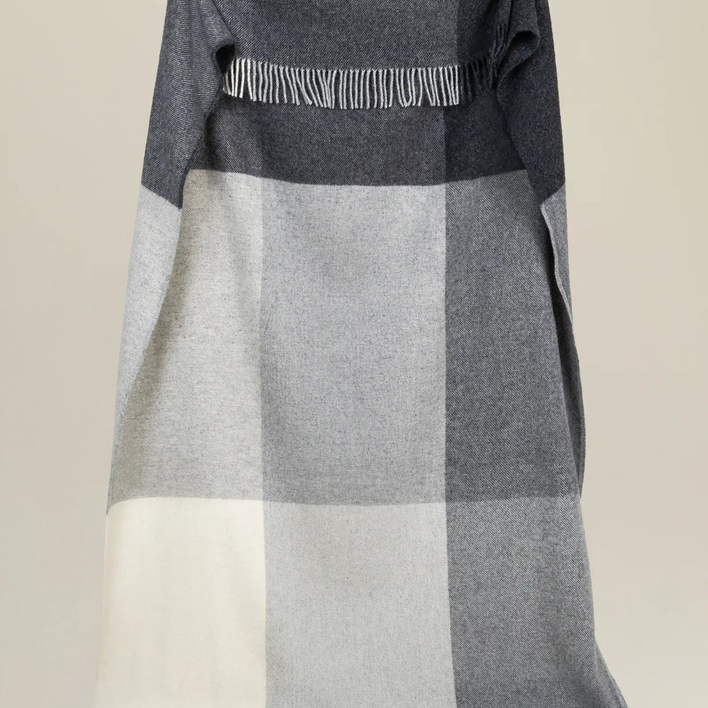 Weave Bayswater Charcoal Throw at Cerise.  Made in 100% New Zealand Wool in a check design in varying shades of charcoal.  Has fringed ends and throw measures 150cm x 240cm