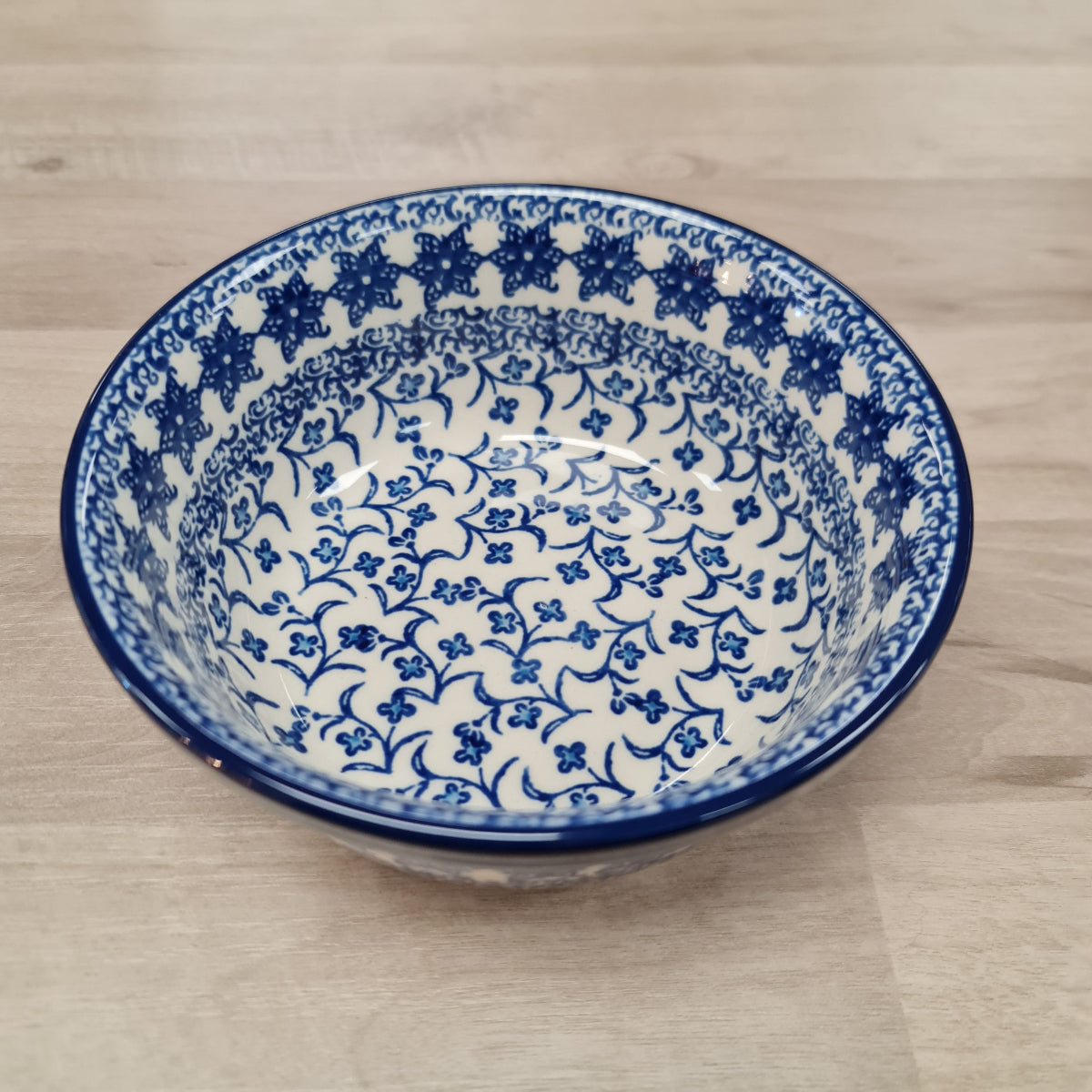 Blue and white patterned ceramic bowl on a wooden surface