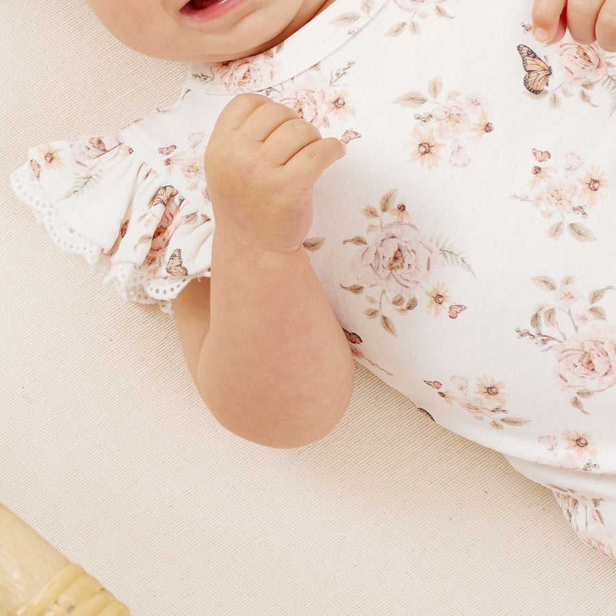 Baby ruffle sleeve onsie featuring a butterfly garden pattern and made of 100% organic cotton