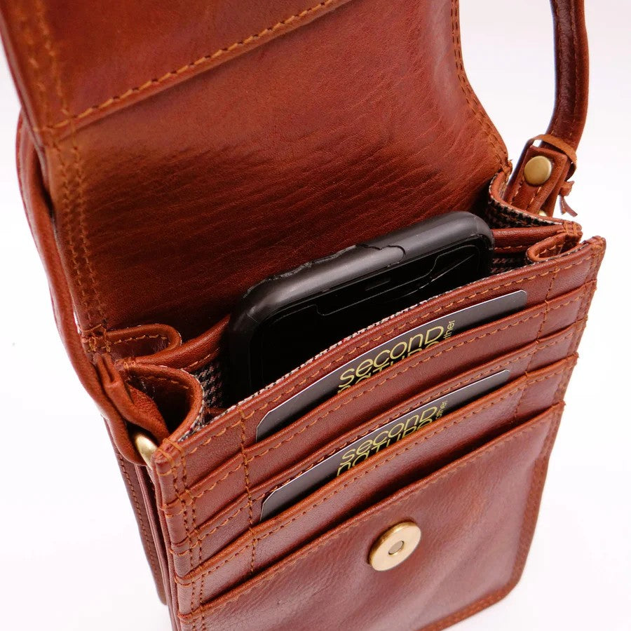 Brown leather wallet with card slots and a phone inside on a white background