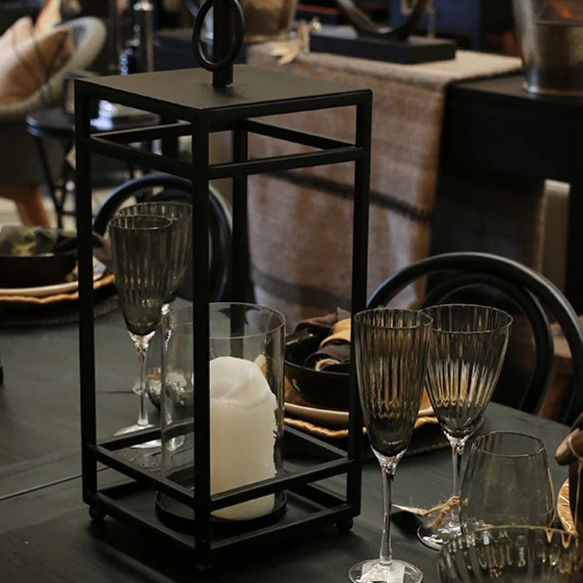 Concept photo of the Ludlow Hurricane Lantern finished in matt black coloured iron with a glass cylinder for your candle from Cerise.