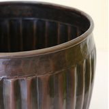 Detail of the CC Interiors Marbella Medium Planter at Cerise in Antique Black colour measures 280mm diameter by 240mm high. Made from aluminium for indoor plant display.