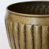 Detail of the CC Interiors Marbella Large and small Planter at Cerise in Dark Antique Brass colour. Large  measures 320mm diameter by 275mm high.  Small measures 225mm Diameter x 180mm High. Made from aluminium for indoor plant display.