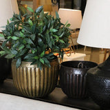 Concept photo of the CC Interiors Marbella Planters on a table setting with artificial greenery and a lamp. 