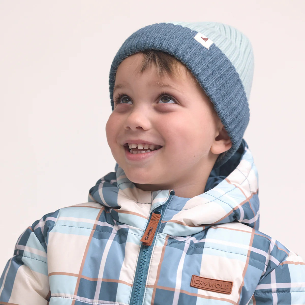 Crywolf Tasman Beanie for children  in Colourblock design availabe in  blue colour at Cerise. Its slimline, no-pom design layers easily under hoods and fits comfortably beneath bike and snow helmets. Made from super-soft Polylana® recyclable fibre, so its lightweight to wear but with the comfort of wool.