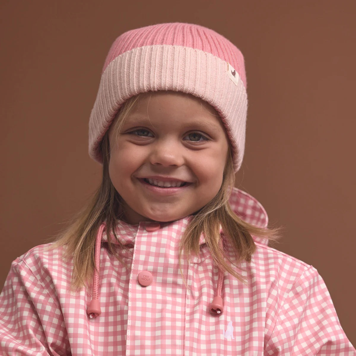 Crywolf Tasman Beanie for children  in Colourblock design availabe in either rose colour at Cerise. Its slimline, no-pom design layers easily under hoods and fits comfortably beneath bike and snow helmets. Made from super-soft Polylana® recyclable fibre, so its lightweight to wear but with the comfort of wool.