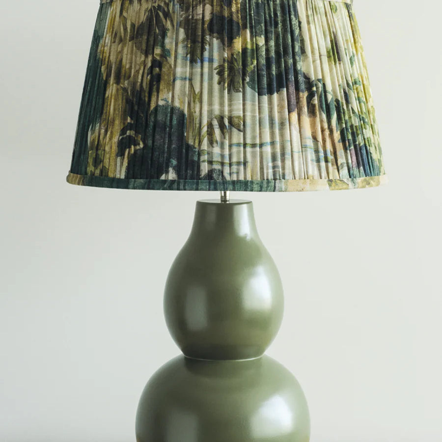 Green curved bulb shape lamp with pleated floral green shade.