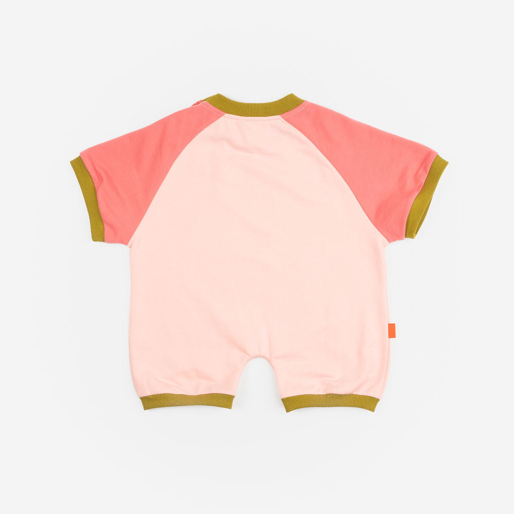 Das Ist Maurice Romper in Pink Petal at Cerise. A sweet, hand-drawn “Pink Petal” artwork sits across the chest, adding a unique and playful touch. Contrasting bright coral raglan sleeves bring a vibrant pop of colour, while olive green ribbed trims.