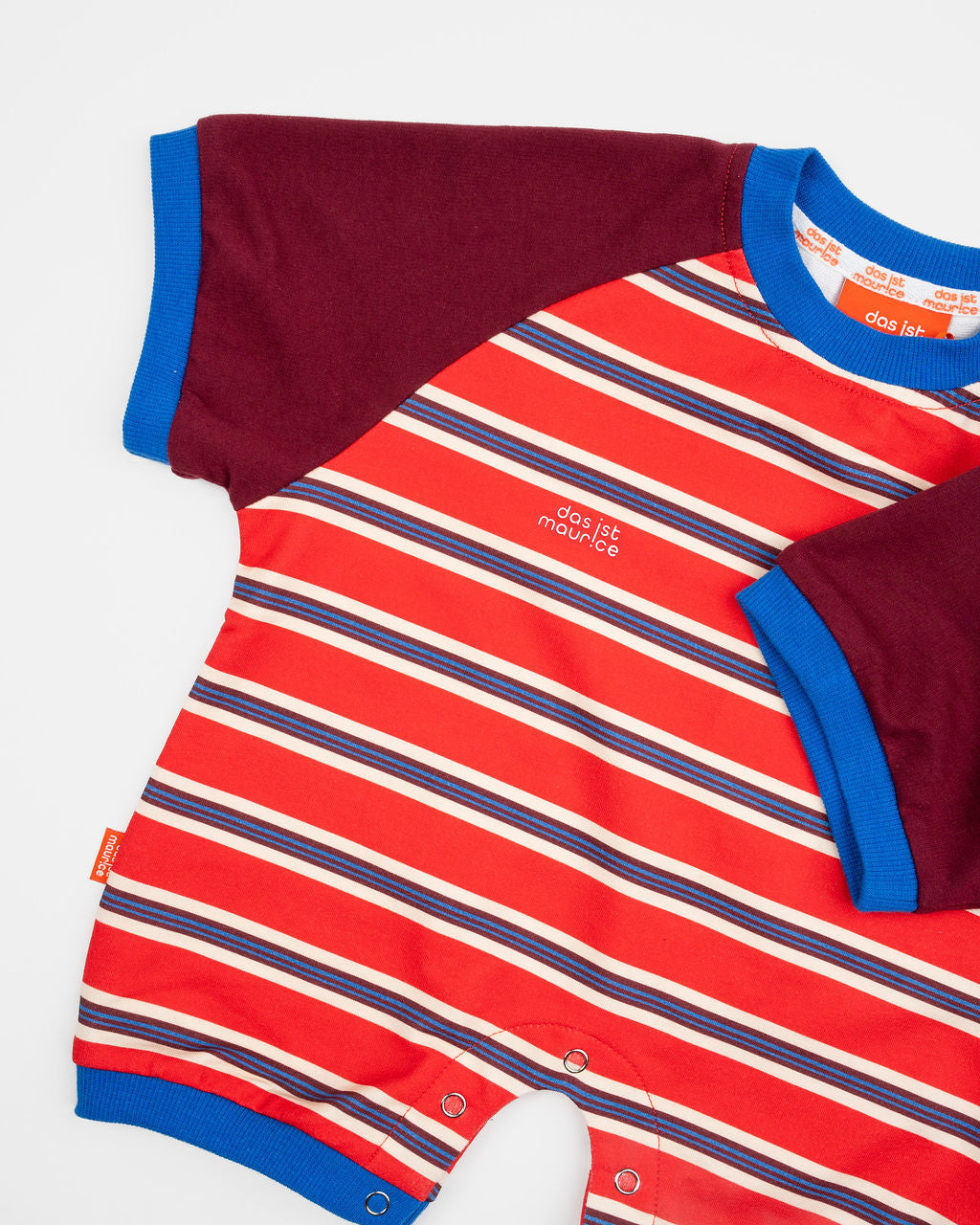 Das Ist Maurice Romper in sunset design featuring bright red and blue striped body with contrast burgundy sleeves bound in a bright blue.  A sporty look for babies and toddlers at Cerise.