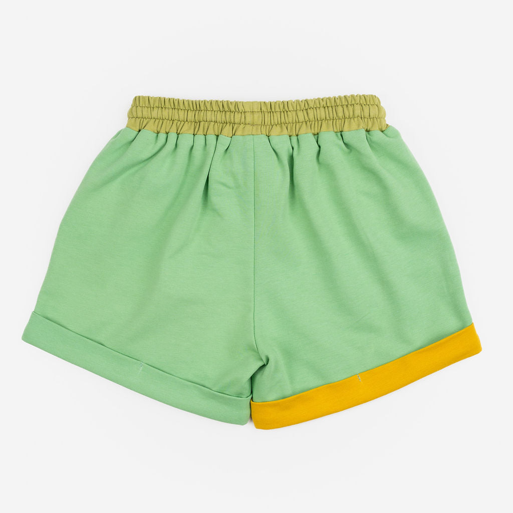 Das Ist Maurice Shorts in Meadow at Cerise. Made from 100% cotton in soft green with  Contrasting pockets, mustard yellow drawstring and rolled cuffs .