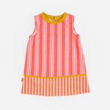 Das Ist Maruice Sleeveless Dress in Coral at Cerise. The relaxed A-line silhouette provides plenty of room for movement, making this sleeveless kids’ dress ideal for active days. Featuring bold coral and peach stripes, the dress has a fun retro-inspired look with a vibrant mustard yellow neckline and contrasting trim